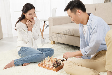象棋游戏摄影照片_青年情侣下象棋