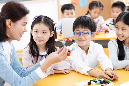 方式摄影照片_女教师和小学生在教室里