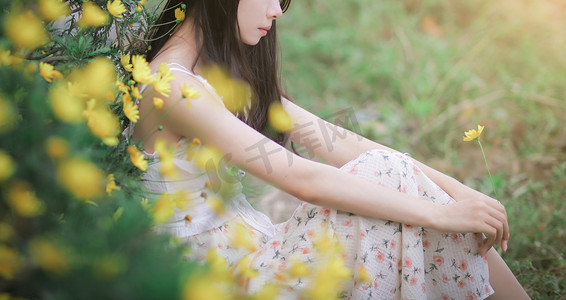 初夏小清新摄影照片_坐在鲜花边上忧郁的美女摄影图配图