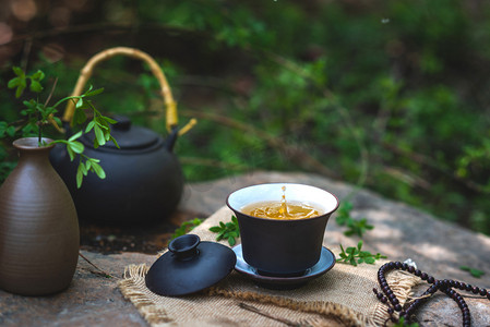 茶壶动画摄影照片_饮品夏季茶石桌倒茶摄影图配图