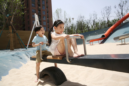 亚洲男孩摄影照片_快乐儿童玩跷跷板