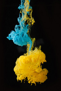 动感例子摄影照片_蓝色和黄色墨水在水中