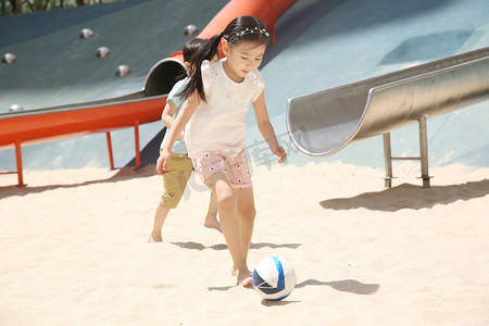 儿童在沙子里踢球