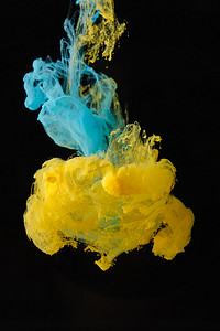 意境设计摄影照片_蓝色和黄色墨水在水中