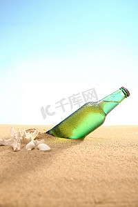 饮料瓶摄影照片_沙滩饮料瓶
