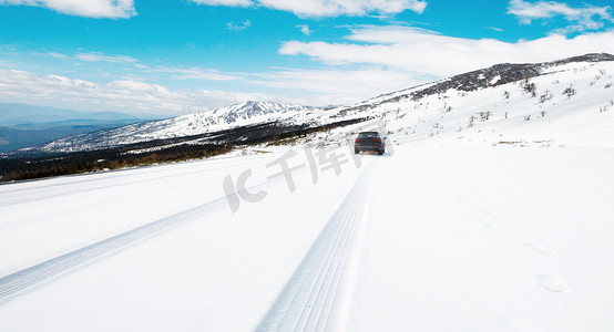 雪地雪山摄影照片_汽车行驶在雪地上