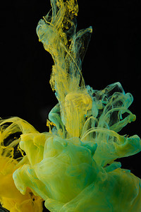 抽象色彩鲜艳背景摄影照片_绿色和黄色墨水在水中