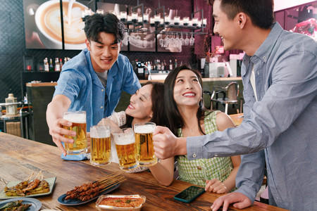 七夕节快乐字体摄影照片_喝啤酒的快乐年轻人