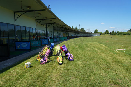 高尔夫球包摄影照片_练习场上的七彩儿童高尔夫球包