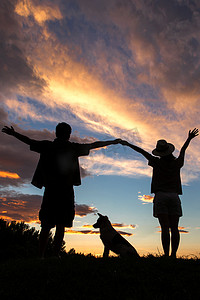 夕阳下的人摄影照片_夕阳下的快乐夫妇和狗