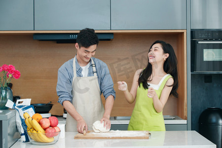 面粉案板摄影照片_青年夫妇在厨房做面食