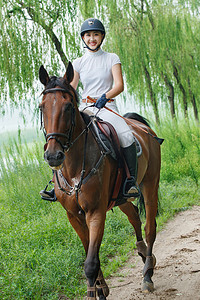 湖边小路骑马的漂亮年轻女孩