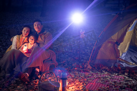 露营灯光摄影照片_幸福家庭夜晚在野外露营