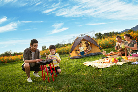 蓝天垫子摄影照片_欢乐的一家人在郊外野餐烧烤