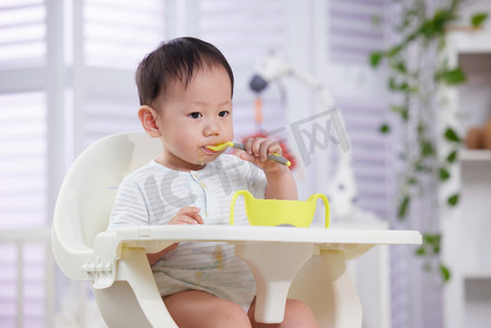 表情人物摄影照片_可爱的宝宝自己吃饭