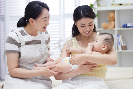 年轻亚洲家庭摄影照片_保姆和年轻妈妈一起照顾宝宝