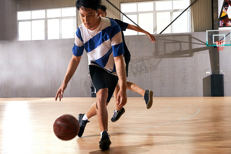 篮球场木地板摄影照片_青年男人打篮球