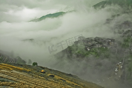 神秘的山丘和村庄在雾中。有薄雾的秋天风景与米梯田。中国, 阳朔, 龙胜