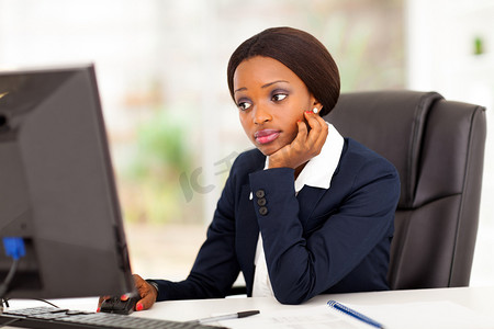 在办公室电脑屏幕前办公的非裔美国女人