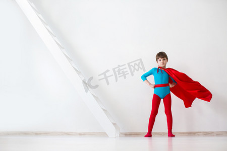领袖。男孩在一件红色斗篷的超级英雄.