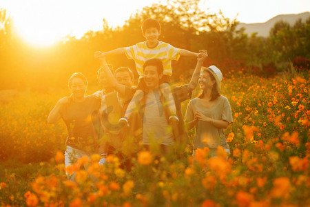 旅游活动中摄影照片_站着花丛中的快乐一家人