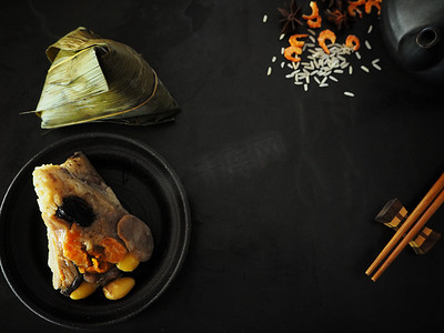 端午背景摄影照片_中国菜黑背景上的茶壶粽子
