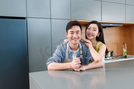 开放式厨房餐桌摄影照片_在厨房里的幸福情侣
