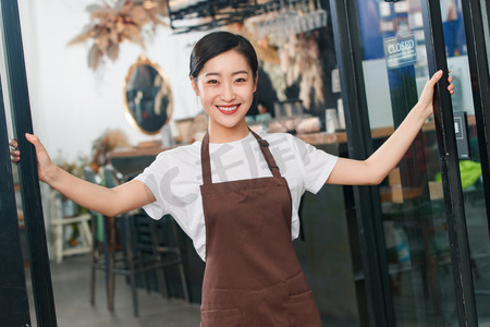 迎接六一摄影照片_咖啡店门口迎接顾客的女服务员