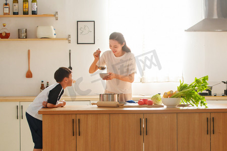 学生做饭摄影照片_年轻妈妈和儿子在厨房