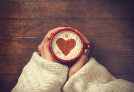 女子持杯热咖啡，与心的形状
