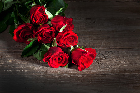 roses摄影照片_Red roses, wooden background
