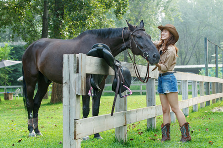 美女和风景摄影照片_牧场内的快乐个性女孩和马