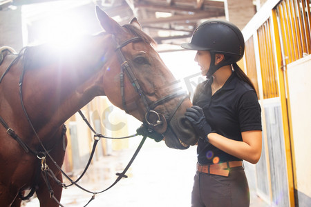 马厩里安抚马匹的年轻女子