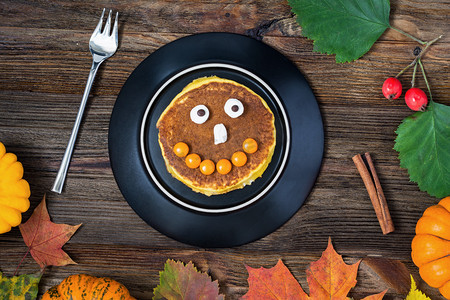 treat摄影照片_Halloween pancake with candy face 