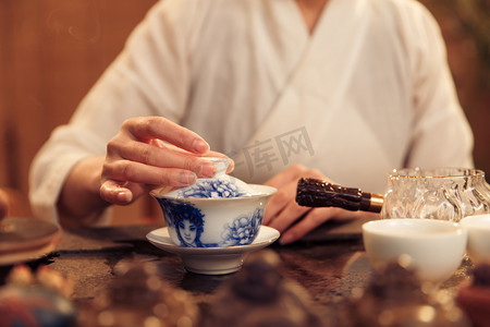 青花瓷茶杯摄影照片_青年女人泡茶