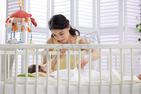 婴儿的日常摄影照片_年轻妈妈陪伴宝宝睡觉