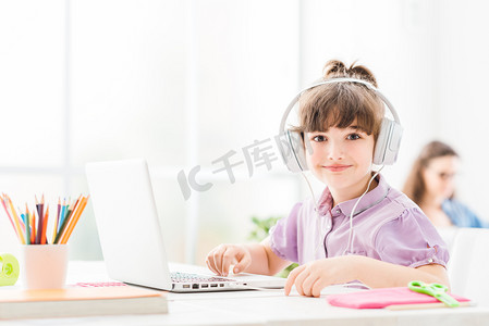 可爱的小女孩带着便携式计算机连接