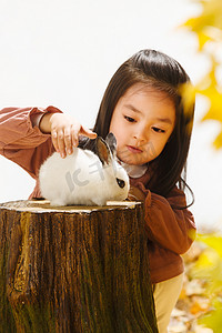 和动物玩耍摄影照片_小女孩和小兔子