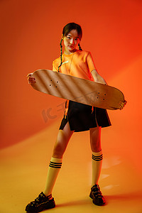 嘻哈嘻哈滑板摄影照片_玩滑板的个性年轻女孩