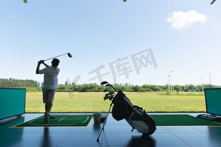 高尔夫球包摄影照片_中年人打高尔夫