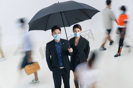 防疫生活摄影照片_拿着雨伞的商务男女戴着口罩站在人群中