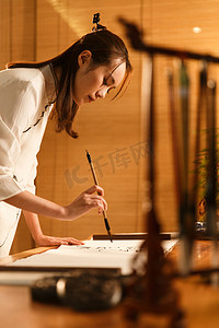 中式书房摄影照片_青年女人在练习书法