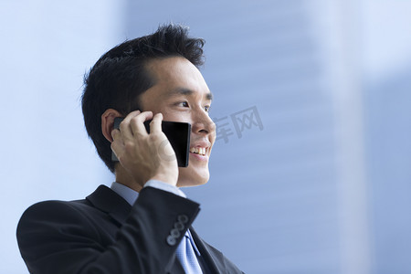 使用智能手机的微笑自信的中国商人