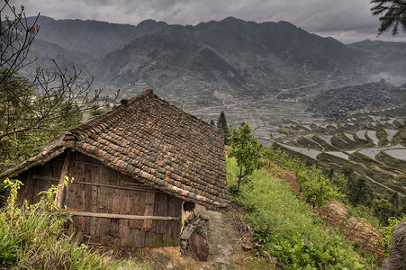 Wooden shed farmers in highlands of China, amid rice fields.