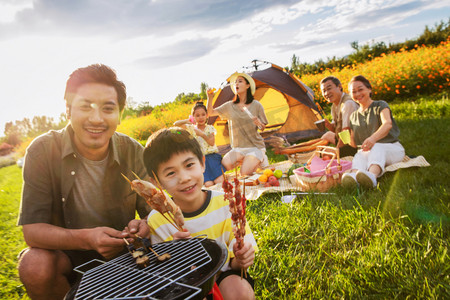 天空温馨摄影照片_欢乐的一家人在郊外野餐烧烤
