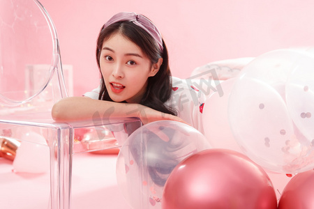 气球粉色摄影照片_漂亮的年轻女孩和气球