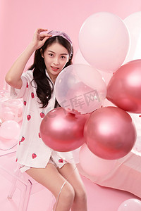 粉色长发女孩摄影照片_漂亮的年轻女孩和气球
