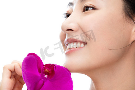 白色玫花背景摄影照片_拿着蝴蝶兰的青年女人
