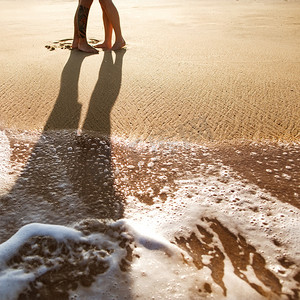 夏天摄影照片_白之恋人站在海边，夕阳的沙滩上的爱