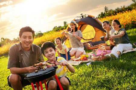串摄影照片_欢乐的一家人在郊外野餐烧烤